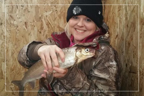 girl holding white fish from ice fishing in sturgeon bay